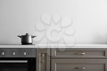 Saucepan on electric stove on counter in kitchen�