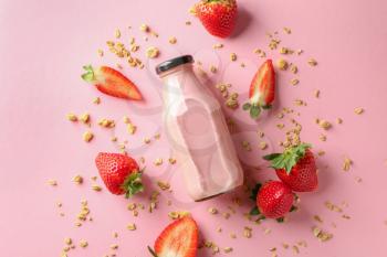 Bottle of strawberry smoothie on color background�
