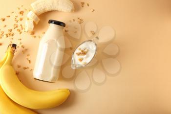 Composition with bottle of banana smoothie on color background�