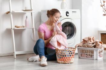 Young woman doing laundry at home�