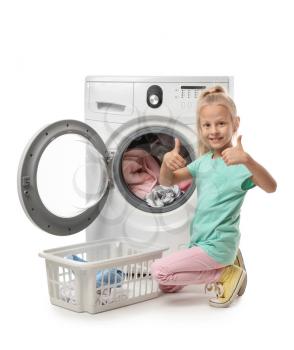 Cute little girl doing laundry on white background�