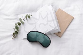 Sleep mask and notebooks on bed�