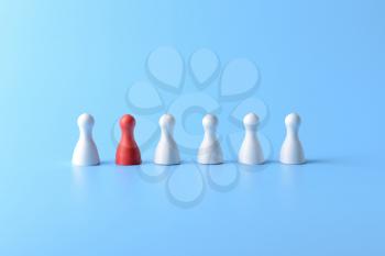 Red pawn among white ones on color background. Concept of uniqueness�