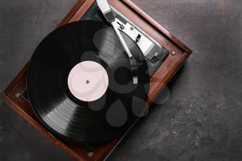 Record player with vinyl disc on grey background�
