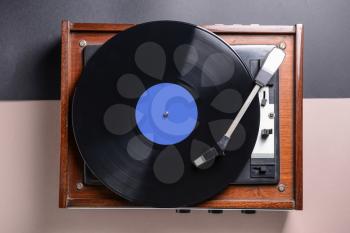 Record player with vinyl disc on table�