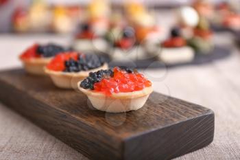 Tartlet with caviar on wooden board, closeup�
