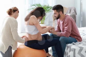 Pregnant couple with doula at home�