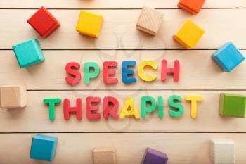 Cubes and text SPEECH THERAPIST on wooden background�