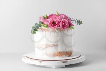 Sweet cake with floral decor on light background�