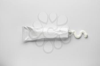 Tube with squeezed paste on white background�