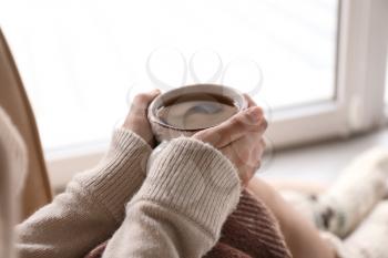 Young woman drinking hot tea at home, closeup�
