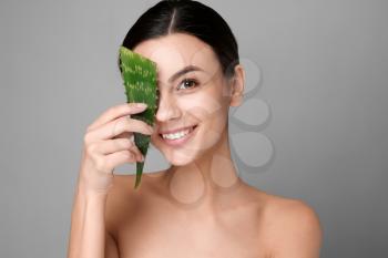 Portrait of beautiful woman with aloe vera on grey background�