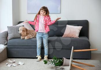 Little girl with dog, dropped houseplant and broken piggy bank on carpet�