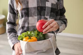 Young woman with fresh vegetables in eco bag, closeup�