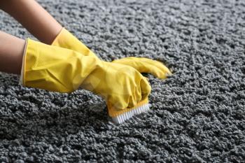 Woman cleaning carpet at home�