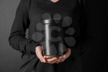 Woman with mortuary urn on dark background, closeup�