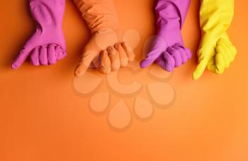 Hands in rubber gloves showing thumb-up on color background�