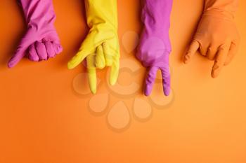 Hands in rubber gloves showing different gestures on color background�