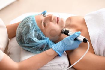 Young woman undergoing procedure of rf lifting in beauty salon�