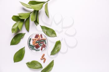 Composition with plant based pills on white background�