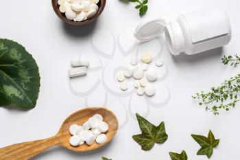 Different plant based pills on white background�