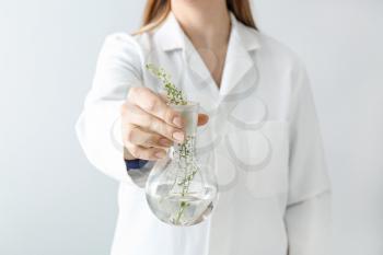 Doctor holding flask with plants, closeup�