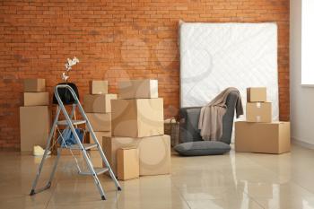 Moving boxes with belongings in empty room�