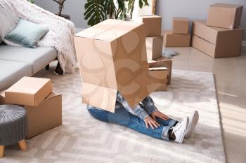 Funny woman with moving boxes in room�