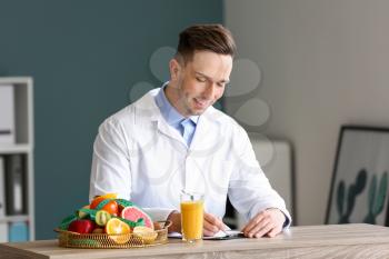 Male nutritionist working in his office�