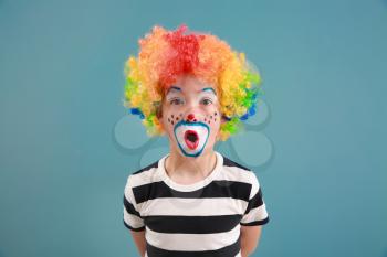 Cute little boy with clown makeup on color background. April fools' day celebration�