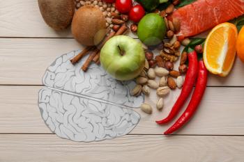 Human brains with different healthy products on white wooden background�