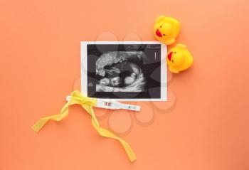 Sonogram image, pregnancy test and toy ducks on color background�