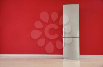 Modern fridge near color wall�