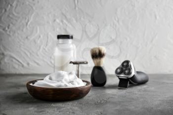 Set of male shaving accessories with foam on table�