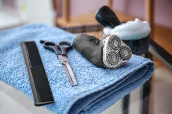 Set of male shaving accessories with towel on glass table�