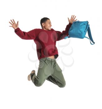 Portrait of jumping African-American teenage boy with backpack on white background�