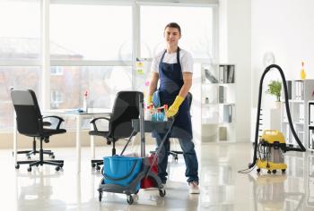 Male janitor with trolley in office�