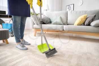 Female janitor cleaning floor in room�