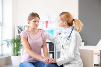 Gynecologist calming young patient in office�