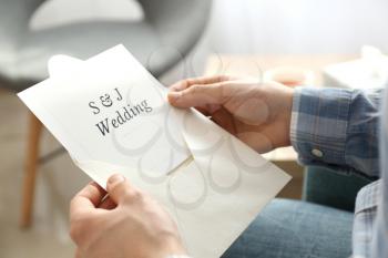 Man holding envelope with wedding invitation, closeup�