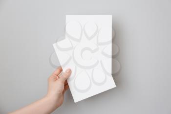 Female hand with blank invitation cards on light background�