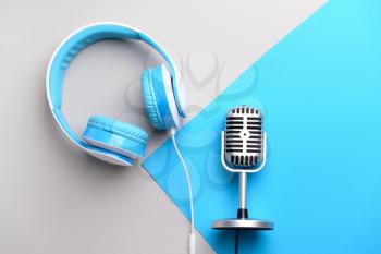 Retro microphone and headphones on color background�