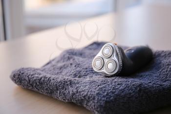 Towel with electric shaver on table�