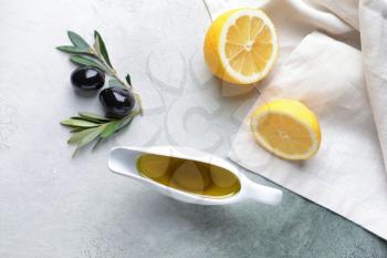 Gravy boat with tasty olive oil and lemon on table�