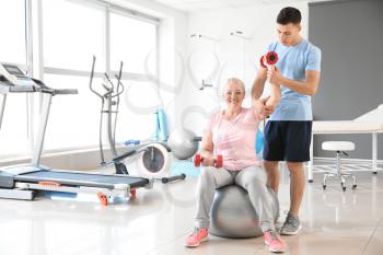 Physiotherapist working with mature patient in rehabilitation center�