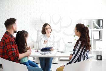 Female psychologist working with family in office�