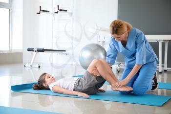 Physiotherapist working with little girl in rehabilitation center�