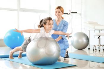 Physiotherapist working with little girl in rehabilitation center�