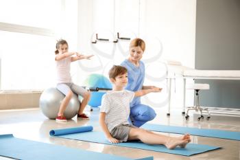 Physiotherapist working with little boy in rehabilitation center�