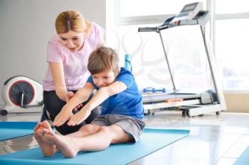 Physiotherapist working with little boy in rehabilitation center�